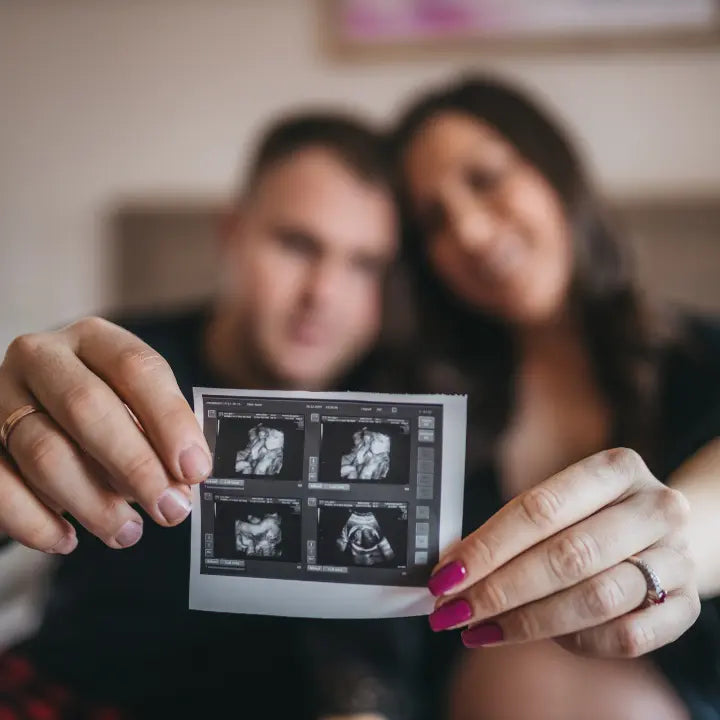 Couple showing an ultrasound picture after successful IVF