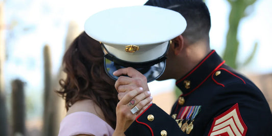 A military couple kissing behind a hat