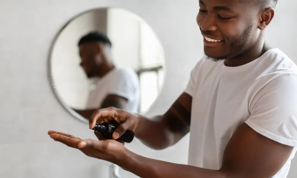 Man holding a black object in front of a mirror