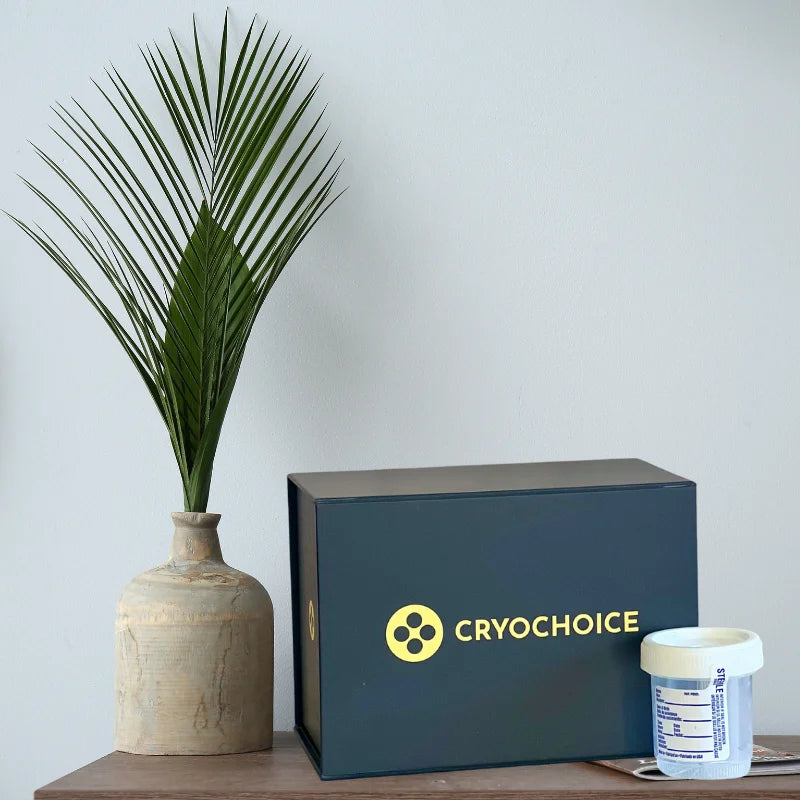 A Blue CryoChoice Sperm collection kit and collection cup on a shelf next to a tan vase with a green plant.