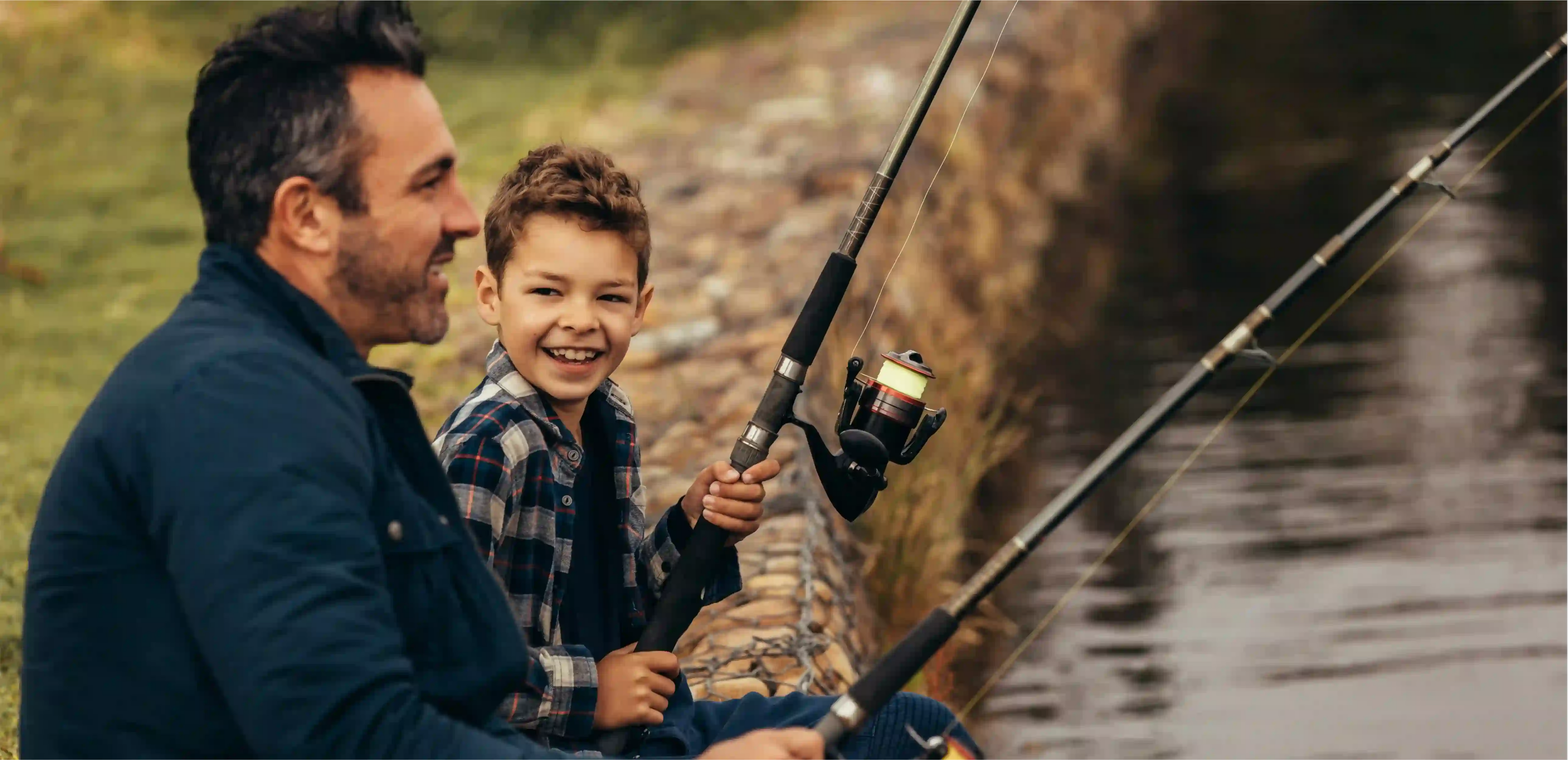 Dad fishing with son on a shoreline