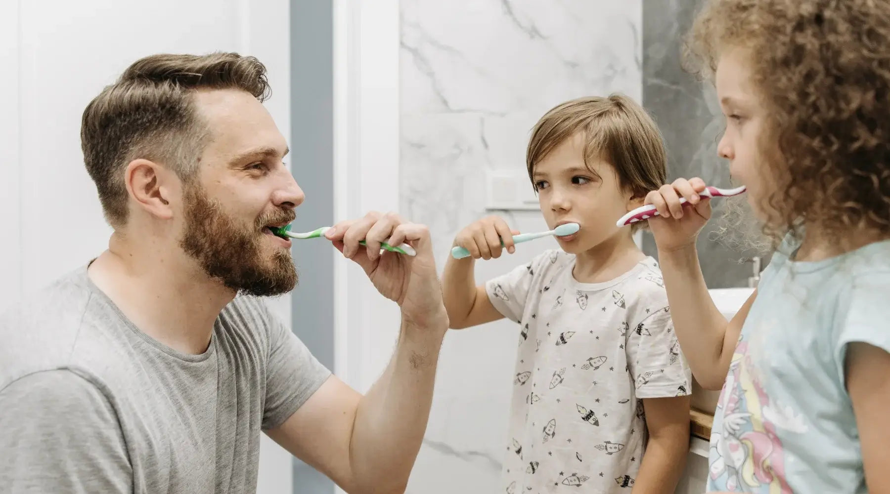 Dad brushing his teeth with two kids