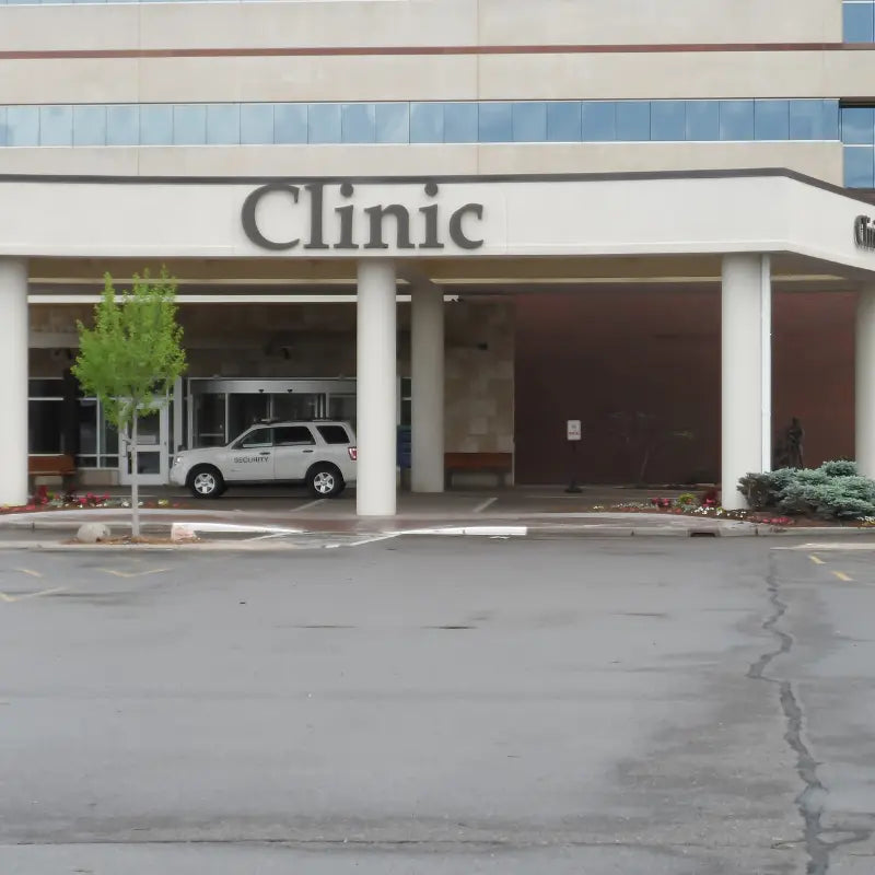 Outside view of a fertility clinic with a white SUV parked in front of it.