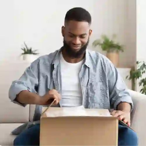 Man opening CryoChoice shipment on his couch containing an at-home sperm collection kit to freeze his sperm for the future.