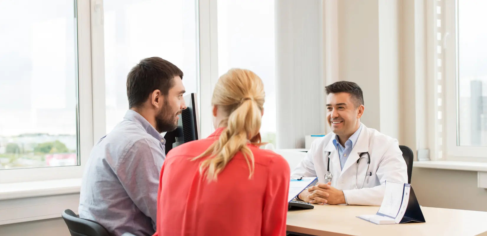 Image shows a doctor and a male and female couple discussing their options on cryopreserving sperm before cancer treatment.