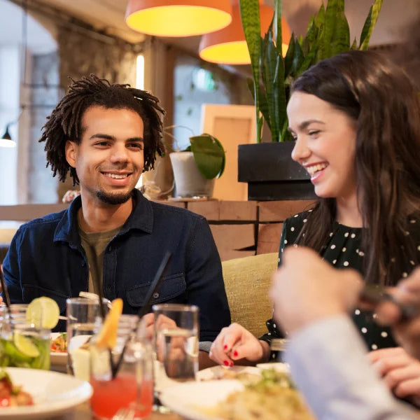 Man and woman laughing over a table at a restaurant