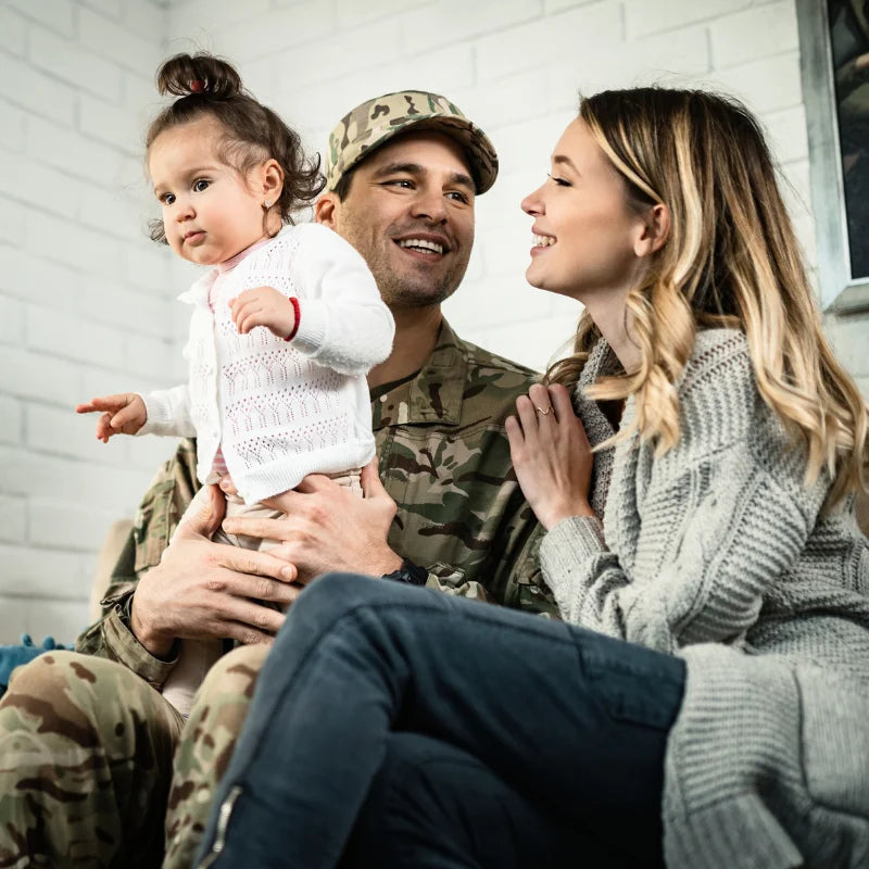 Man in military uniform with wife and daughter smiling