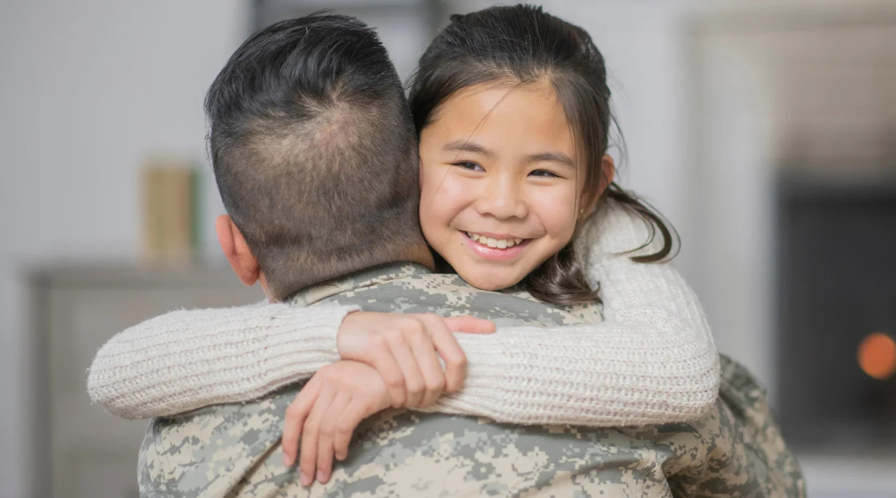 Military man hugs daughter