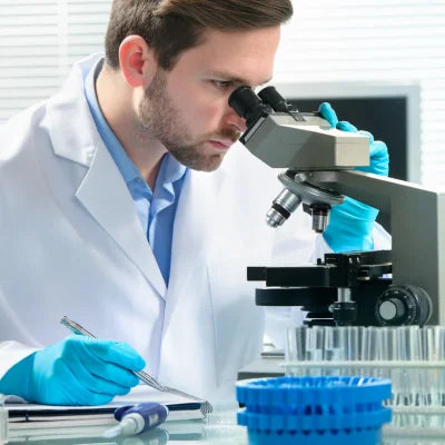 Man in a lab coat looking at a microscope analyzing the health of sperm from a CryoChoice Sperm Analysis